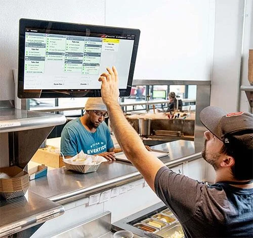 A man using a big screen at the order counter