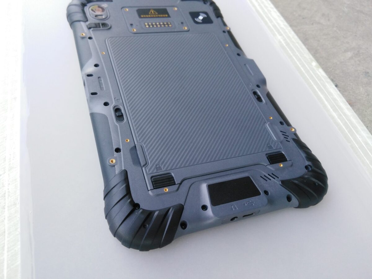 The back of a GK-ST8-QC 8" Android Rugged Tablet with 1D/2D Barcode scanner on a table.
